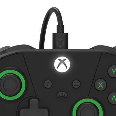 Black gaming controller with green accents on a white background