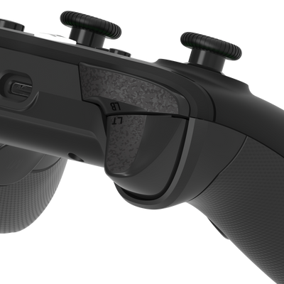 Close-up of a black gaming controller with textured grip and buttons on a white background